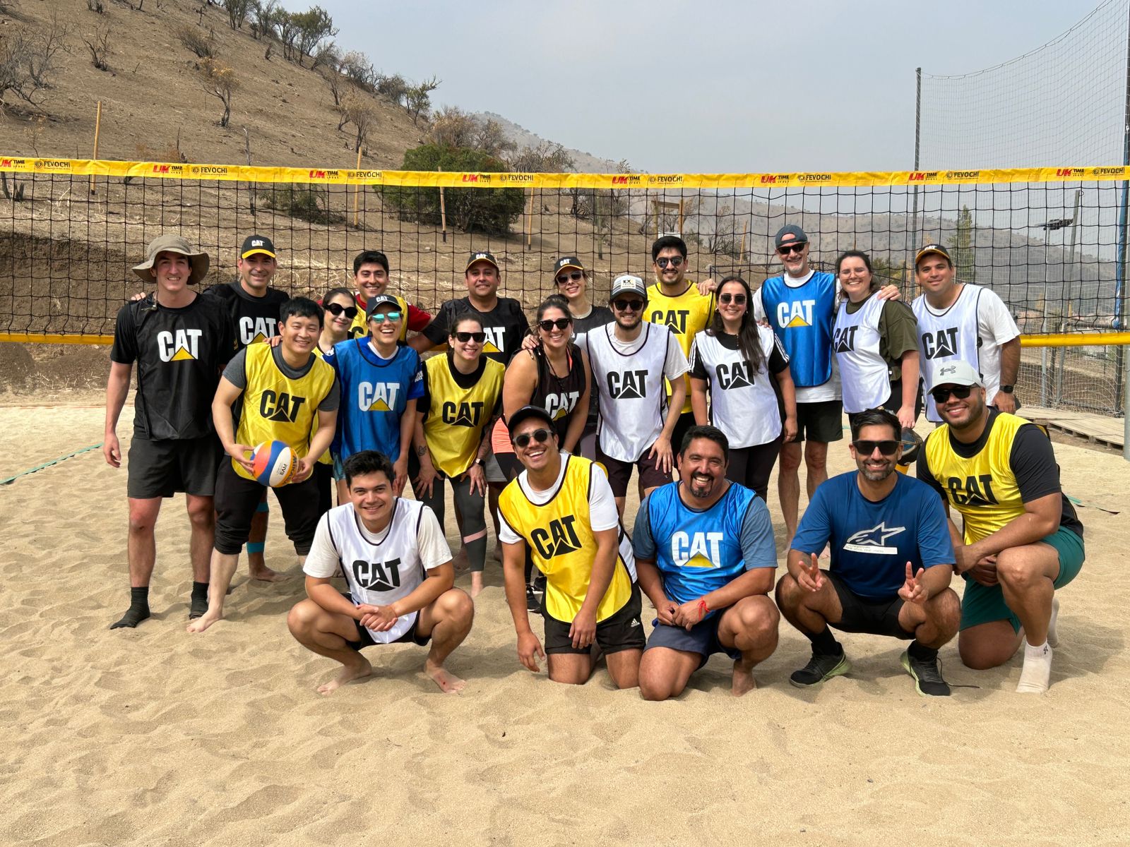 Equipo de empresa jugando beach volley en cancha de arena en Sportpark Huechuraba