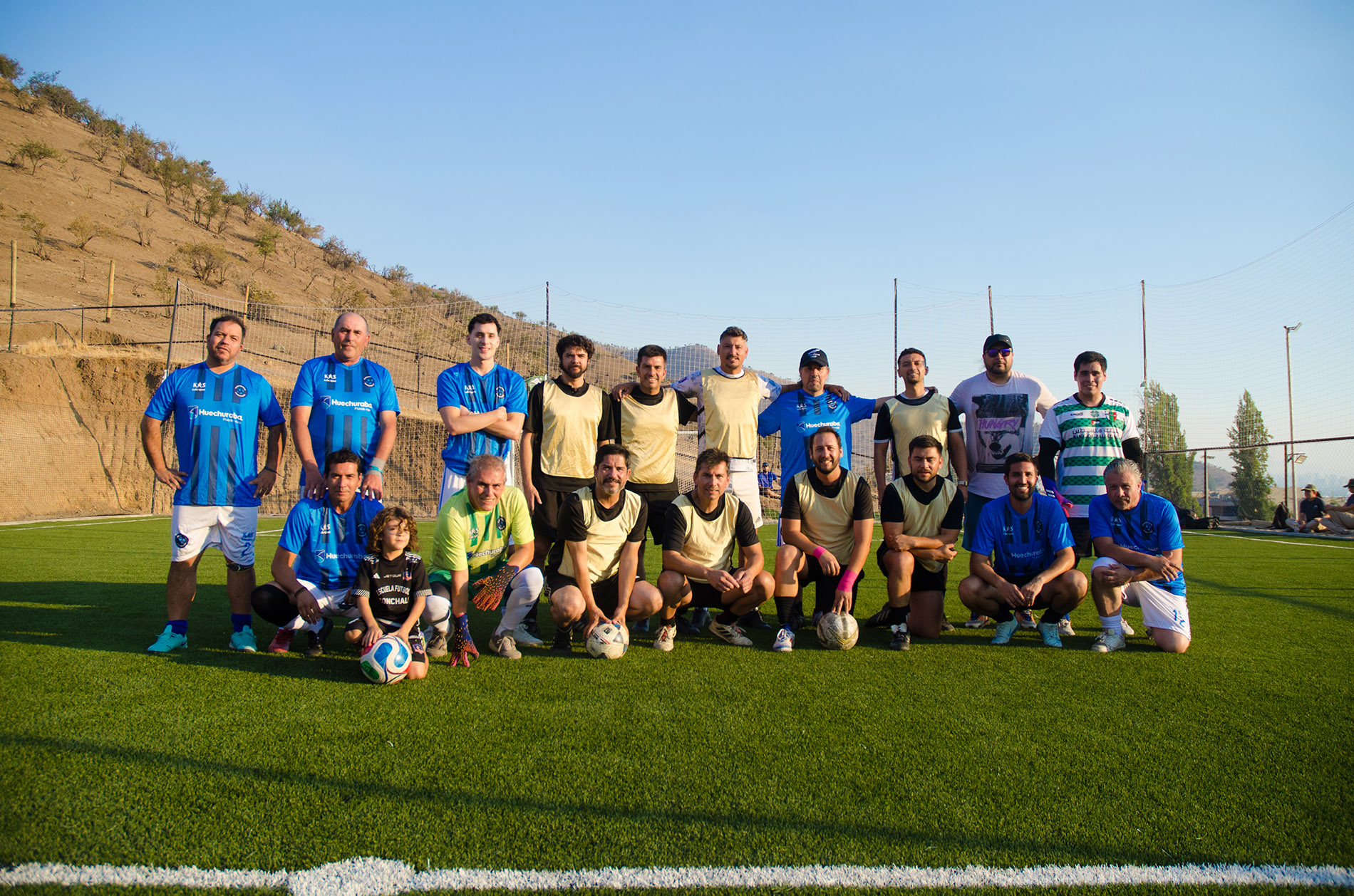 Equipo corporativo posando juntos en cancha de beach volley en Sportpark Huechuraba