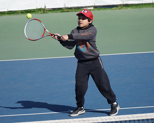 Niño jugando tenis en sportpark